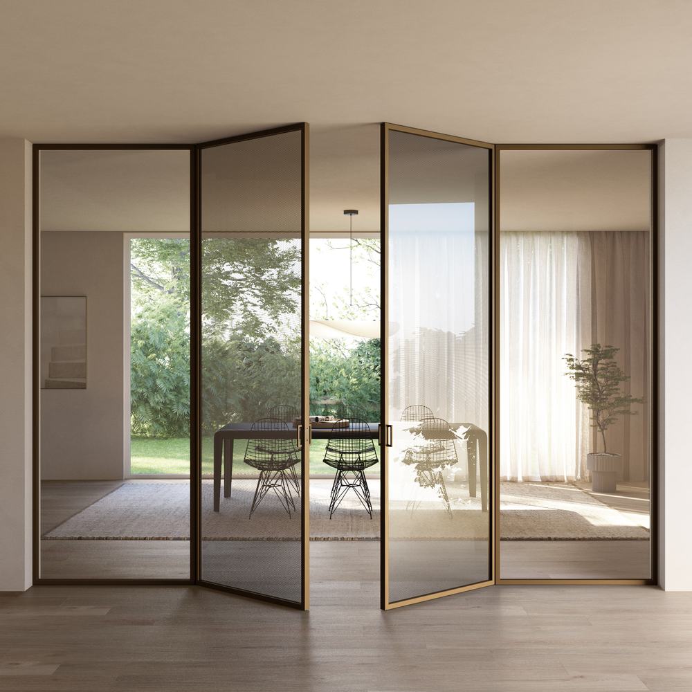Porte a vetri con telaio in bronzo che si aprono su una sala luminosa con giardino