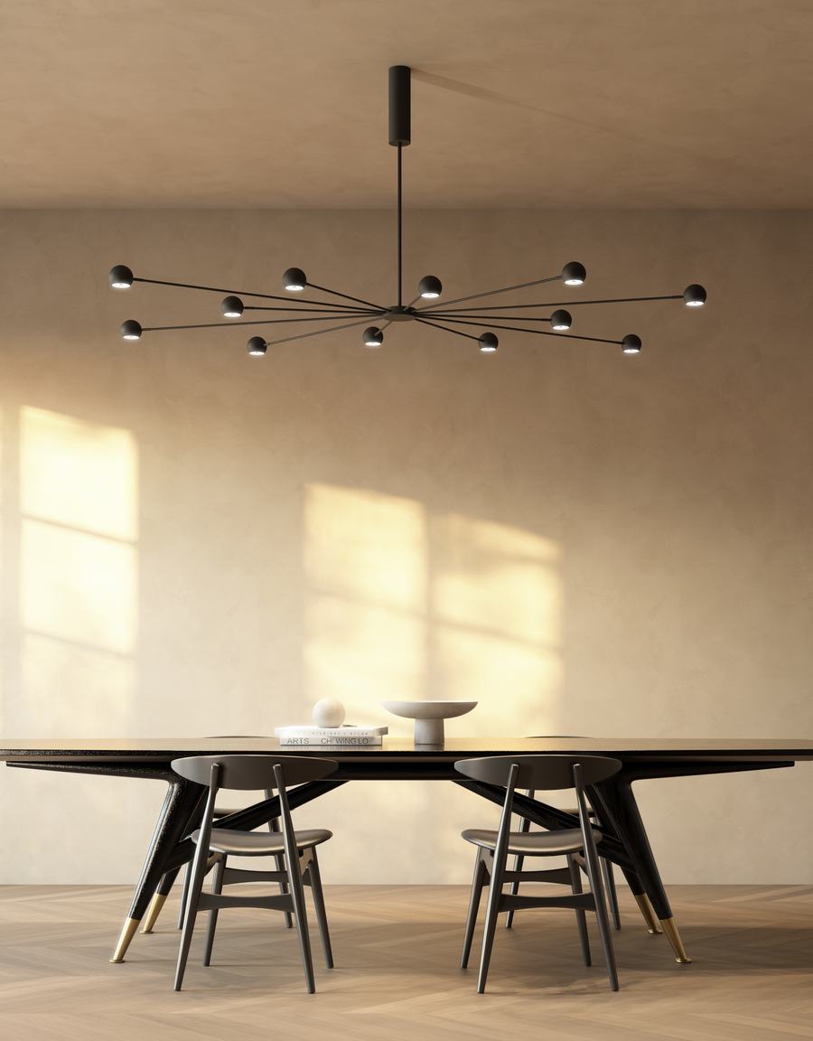 Tavolo scuro con sedie in legno e grande lampadario a bracci neri