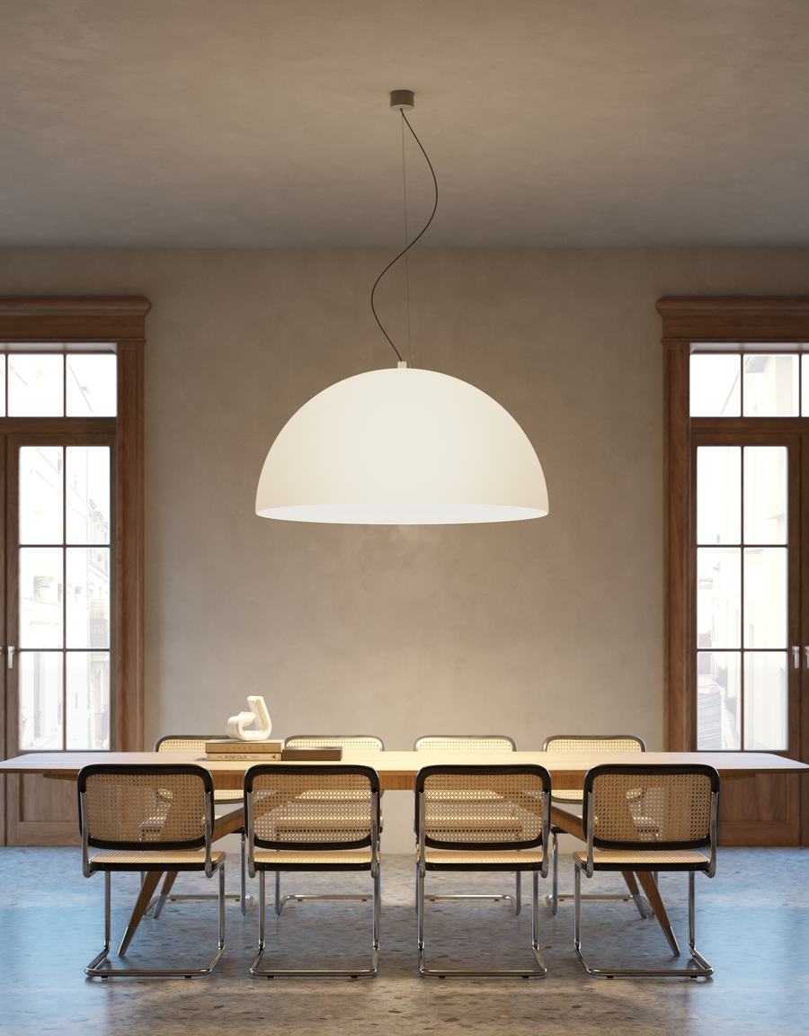 Sala da pranzo con grande lampada a cupola e sedie con schienale intrecciato