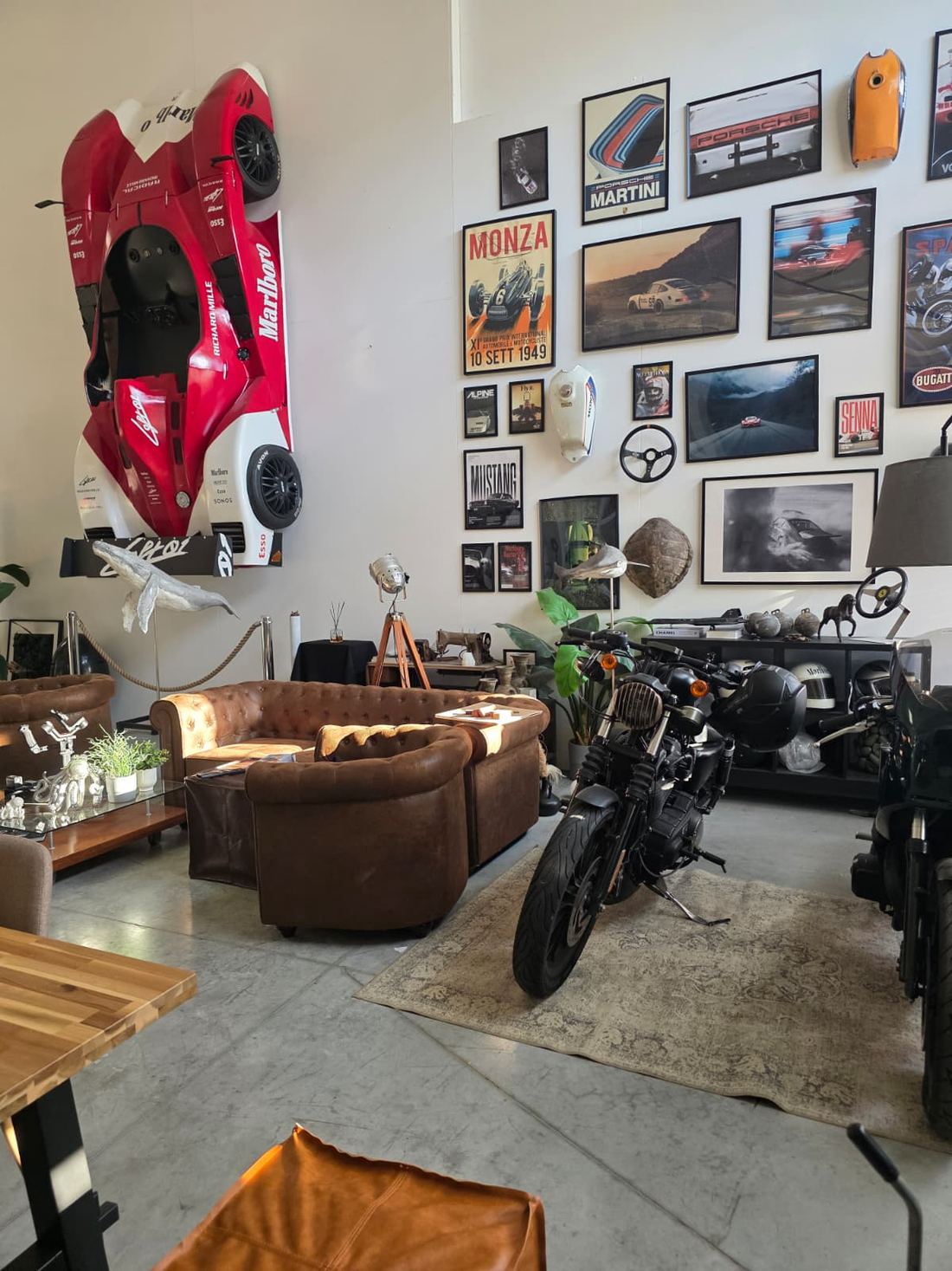 La zona relax dello studio, con divani in pelle, moto e pareti di quadri